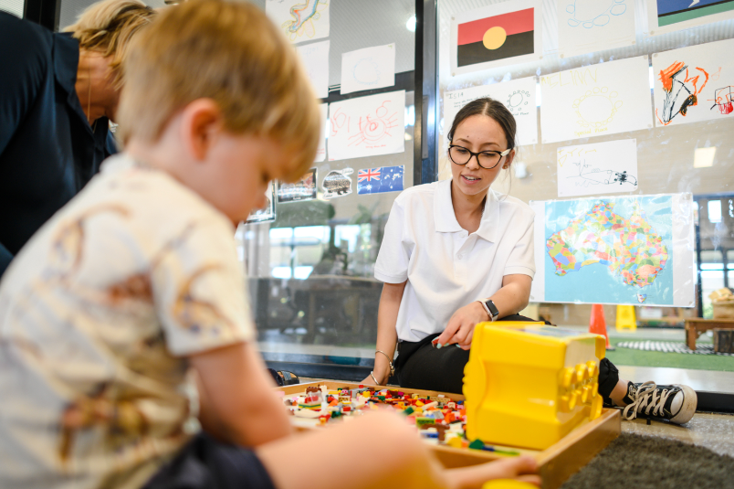 childcare worker and child playing